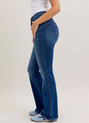 Person wearing blue jeans on a plain background