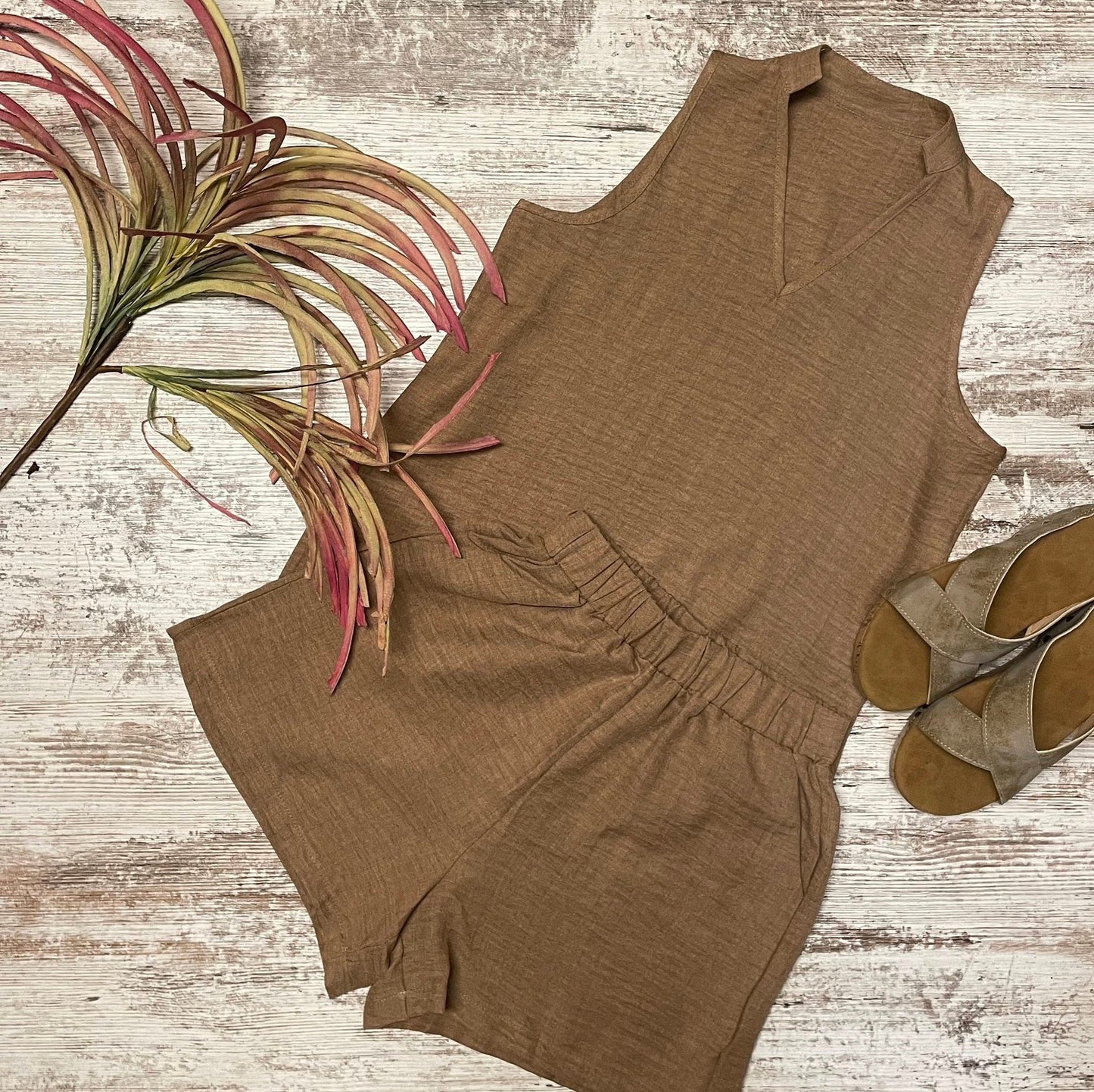 Brown sleeveless top and shorts set with shoes and plant on a wooden surface
