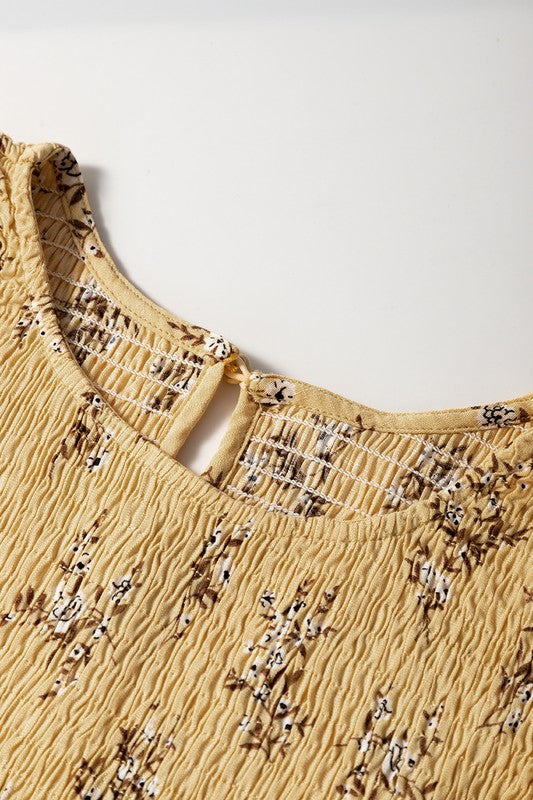 Close-up of a yellow top with floral embroidery on a white background
