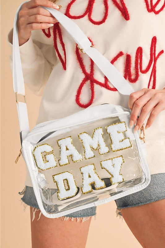 Clear bag with 'GAME DAY' text held by a person wearing a red and white outfit.