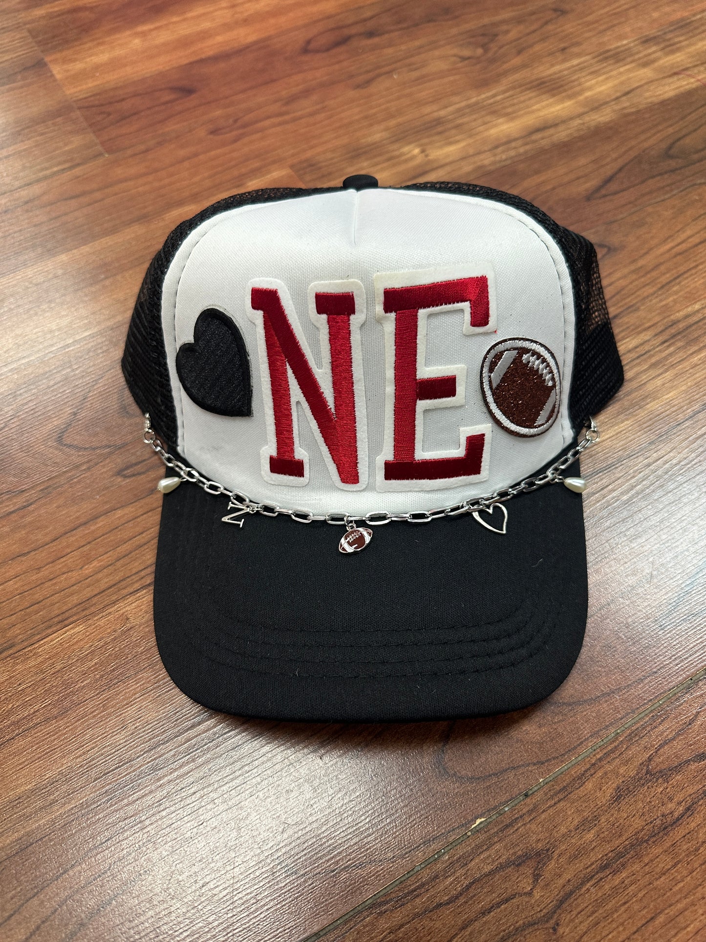 Black cap with a white patch featuring red text on a wooden surface