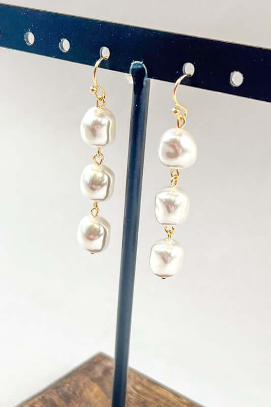 Fishhook drop earrings featuring three pearls in a straight dangle, lightweight