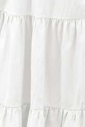 Close-up of a white dress with ruffled layers