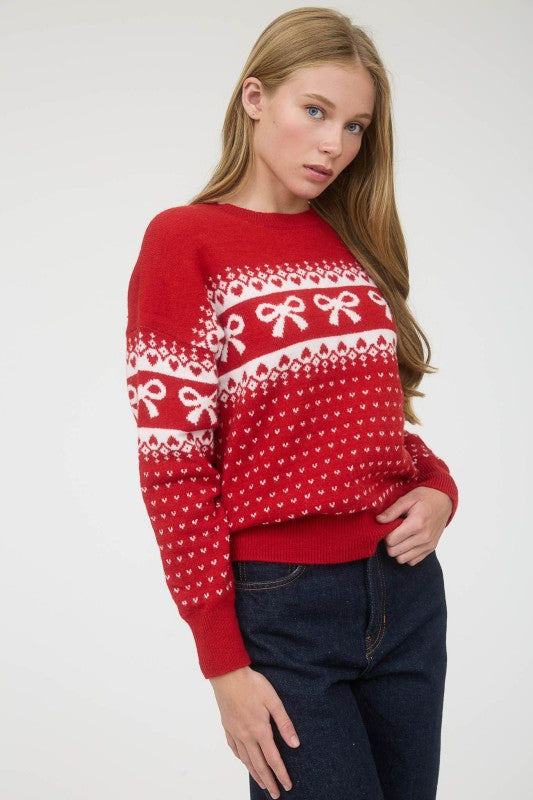 Woman wearing a red sweater with white patterns on a plain background