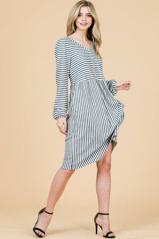 Woman wearing a black and white striped dress on a beige background