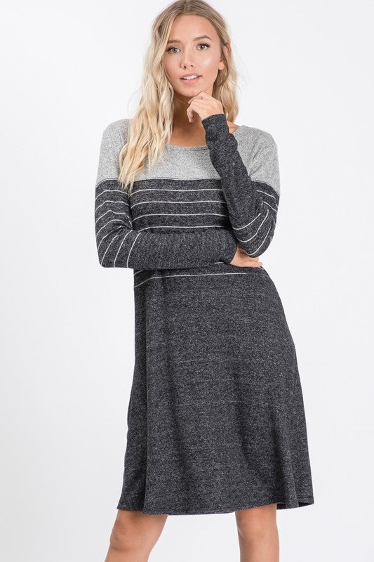 Woman wearing a gray and black striped dress on a white background