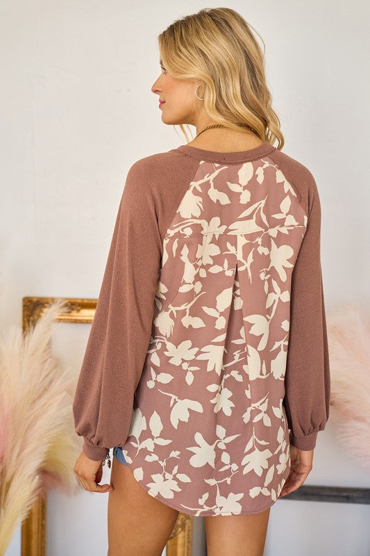 Woman wearing a brown floral dress against a neutral background