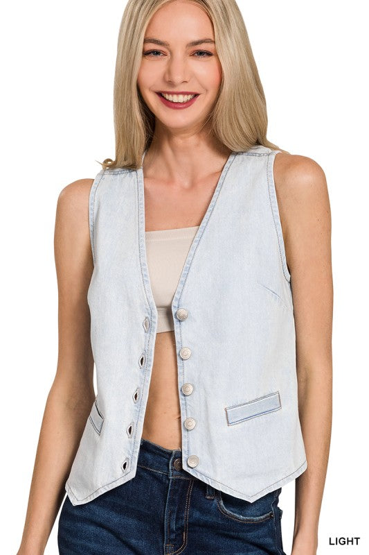 Woman wearing a light blue denim vest over a beige top and blue jeans on a white background