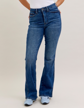 Person wearing blue jeans on a plain background