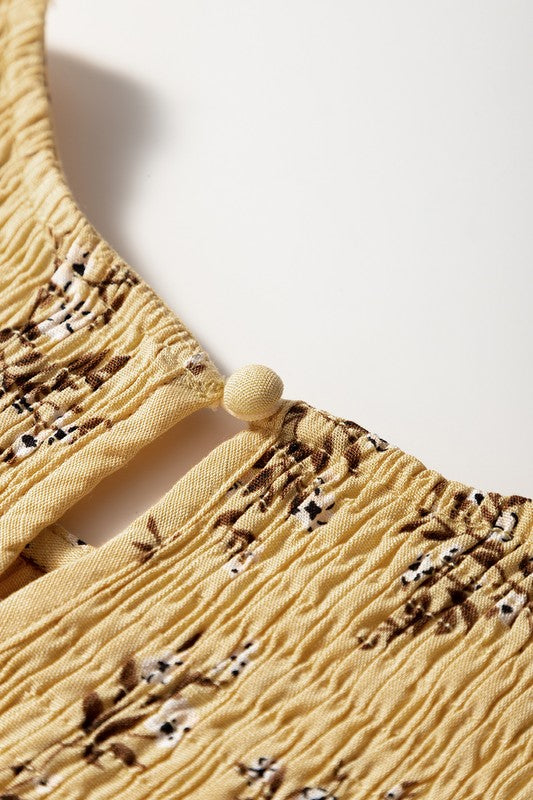 Close-up of a yellow textured garment with floral patterns on a white background