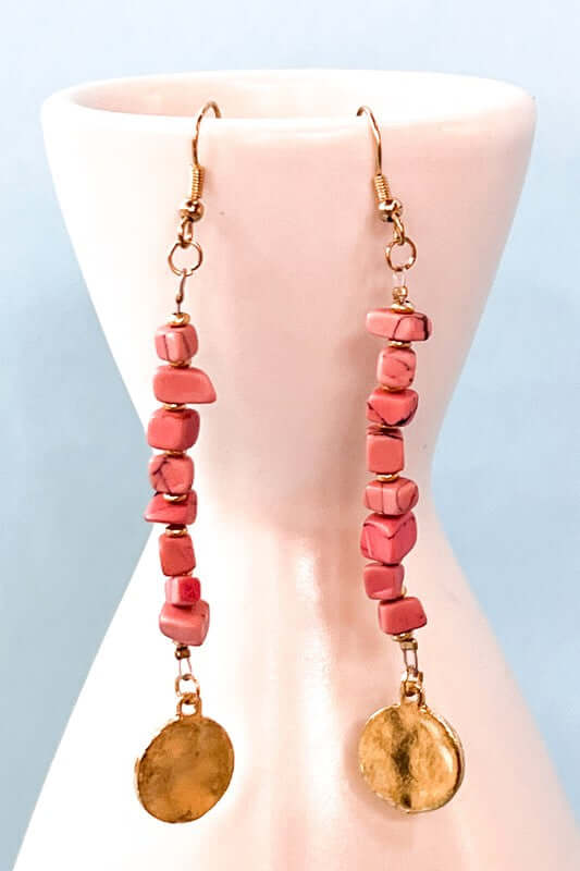 Blush Coral and gold beaded earrings against a light blue background