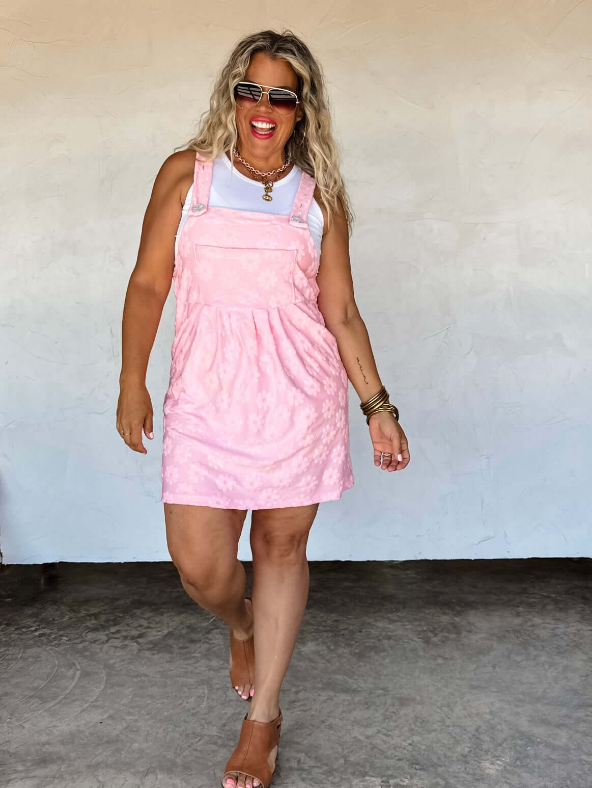 Woman wearing a pink quilted dress against a plain background