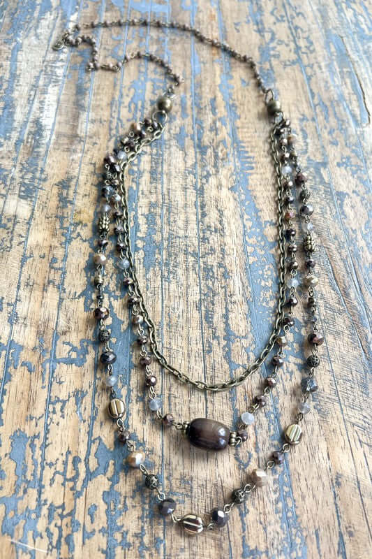 Necklace with beads on a textured wooden surface