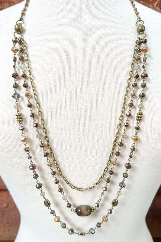 Multistrand beaded necklace on a mannequin with a plain background