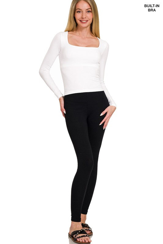 Woman wearing a white top and black leggings on a white background