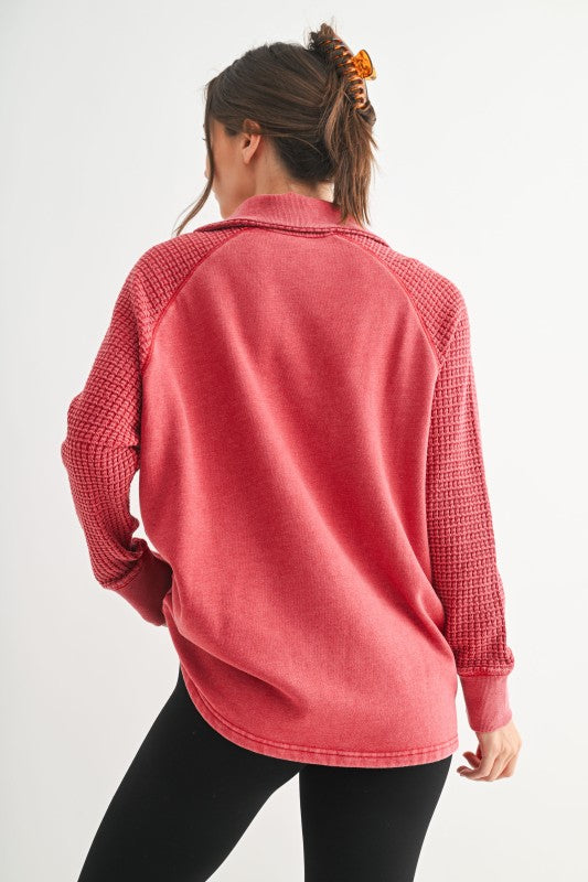 Person wearing a red textured sweater on a white background