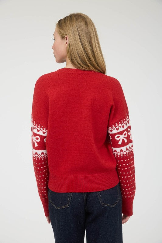 Person wearing a red sweater with white patterns on a plain background