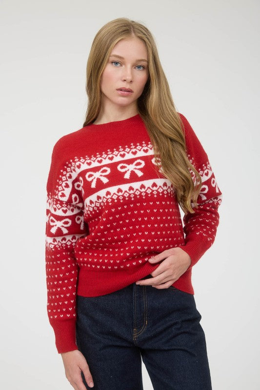 Person wearing a red sweater with white patterns on a plain background