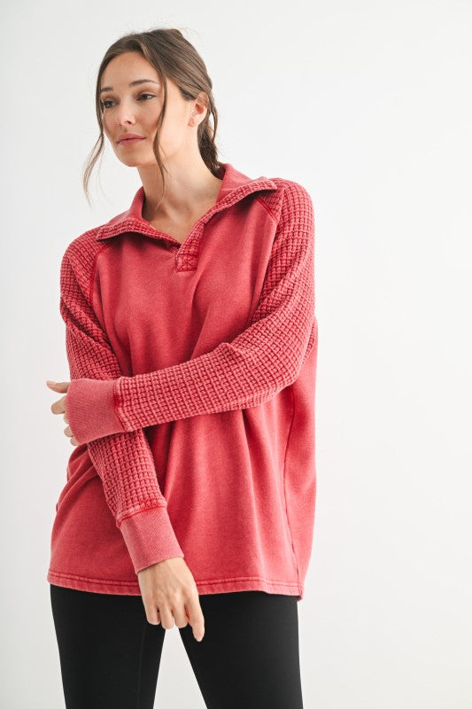 Woman wearing a red textured sweater on a white background