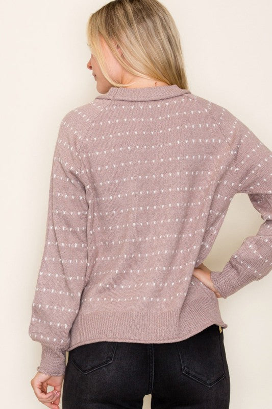 Woman wearing a patterned sweater against a plain background
